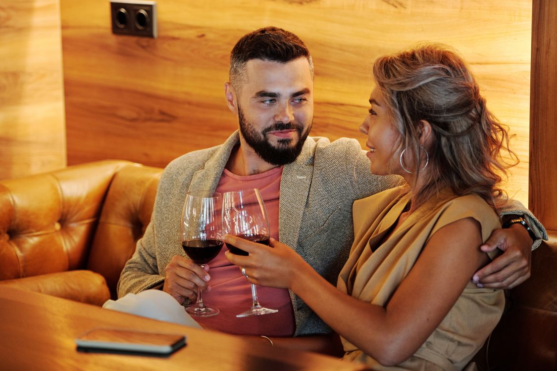 Elegantes Paar stößt mit Weingläsern in einem stilvollen Restaurant an