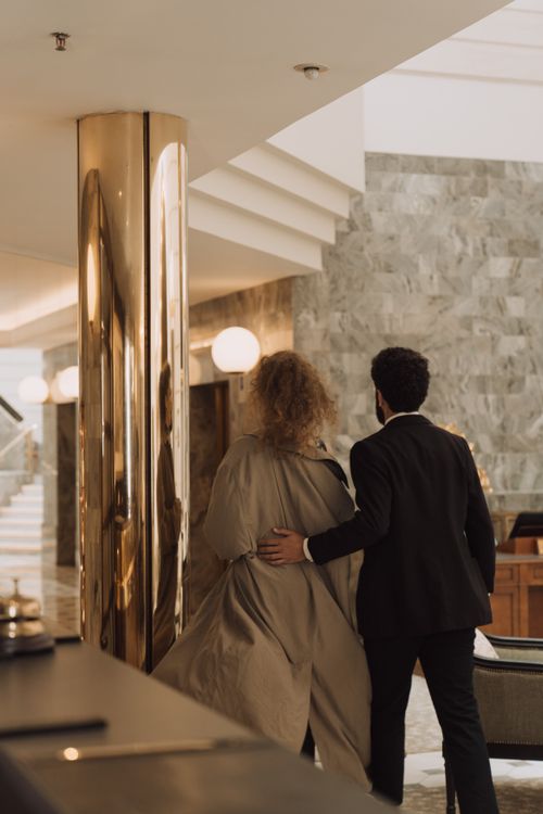 Elegantes Paar betritt die Lobby eines gehobenen Hotels